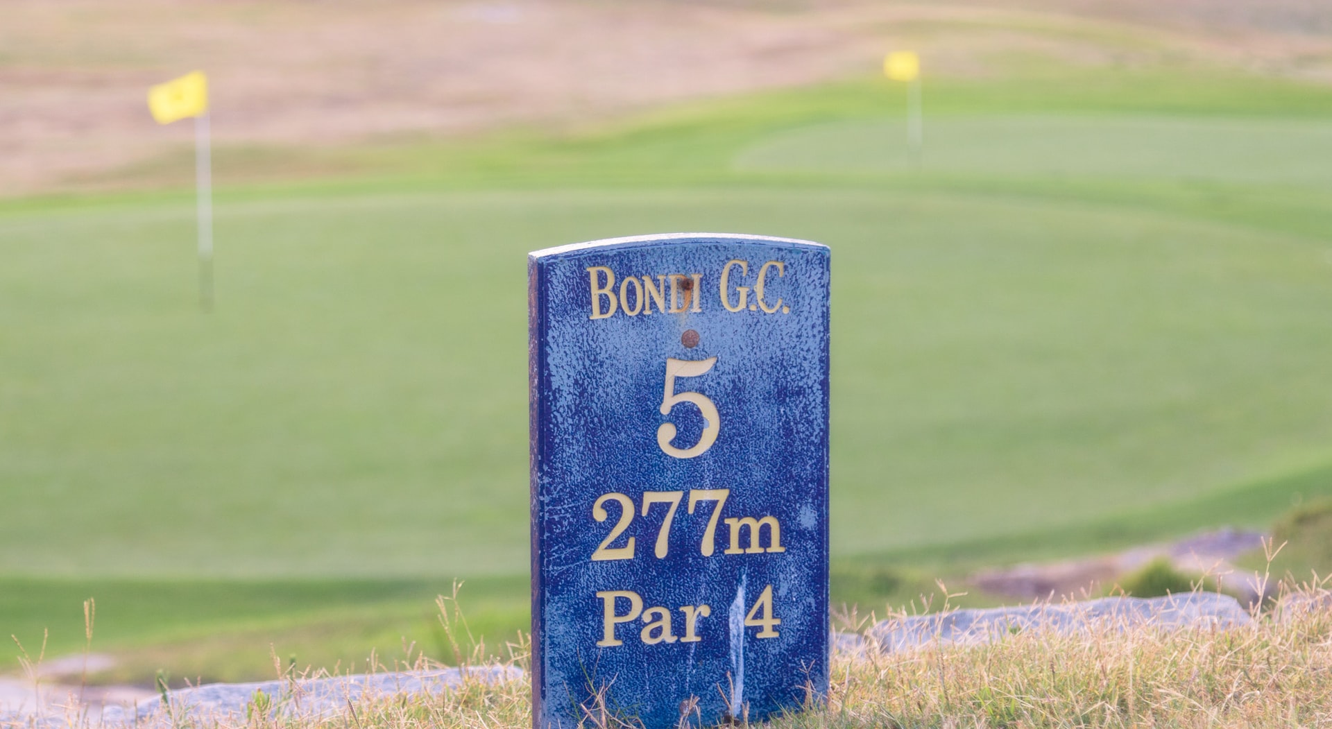 A blue tee marker reading Bondi G.C. 5, 277m, Par 4, yellow flags on the greens behind